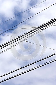 View on electricity cables high up in the sky in a city environment.