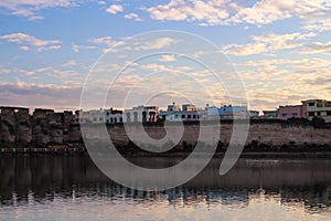 View of the embankment, Bassin Souani, colorful houses, ruins of ancient stables and reflection in the water, Meknes city.