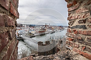 View through an embrasure in the castle wall of the fortress Feste Oberhaus near the three rivers city Passau with view on the cit