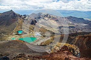 View of Emerald lakes from Tongariro Alpine Crossing hike with clouds above, North Island, New Zealand