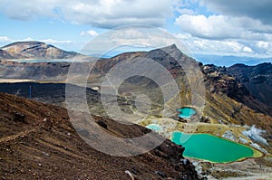 View of Emerald lakes from Tongariro Alpine Crossing hike with clouds above, North Island, New Zealand