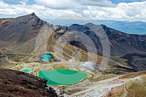 View of Emerald lakes from Tongariro Alpine Crossing hike with clouds above, North Island, New Zealand