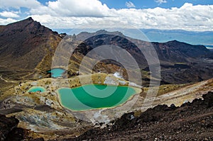 View of Emerald lakes from Tongariro Alpine Crossing hike with clouds above, North Island, New Zealand