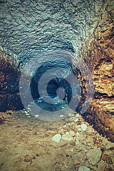 View into an empty medieval catacomb. Tunnel excavated in orange sandstone rock