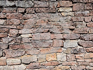 View of empty, old white, pink and grey brick wall background with copy space. A deteriorating old brick wall outdoors