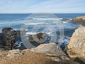 View of empty Praia Selvagem sand beach with ocean waves and sharp rock and cllifs at wild Rota Vicentina coast near