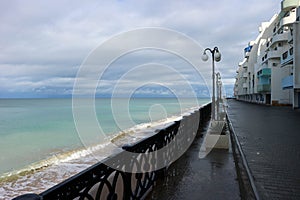 view of empty seaside promenade and sand beach in stormy autumn day