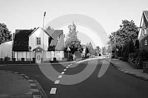 View of empty street in neighborhood suburban area in Germany during summer. Black and white image.