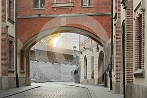 View of an empty street without people of the old city in Krakow, Florianska at dawn. A cobblestone road, old red-brick