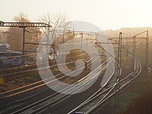 View of the empty trackway with railway tracks during sunrise with fog during summer in Przemysl