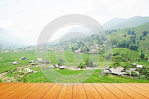 The view of the empty wooden table with the upper farmer village and the mist on the mountain beautiful background