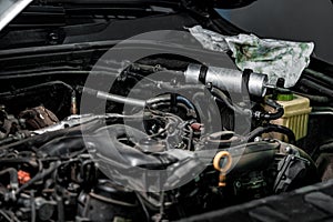 View of engine and other parts under the open hood of a car