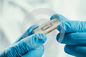 View of engineer in rubber gloves holding computer microchip