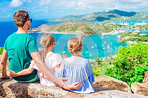 Adorable little kids and young father enjoying the view of picturesque English Harbour at Antigua in caribbean sea