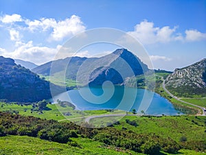 View of Enol Lake in Covadonga Lakes, Asturias, Spain, from the lookout. Green grassland with mountains at the background photo