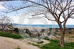 The view from lookout above the Patras city in Greece with a tree and a bench to relax and admire the beautiful cityscape