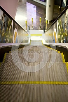 View at escalator with metal railing going down