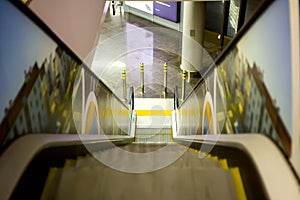 View at escalator with metal railing going down