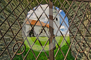 View of The Evangelical Church in Rimavska Bana throught the metal gate