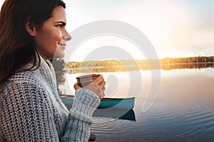 This view is everything. an attractive young woman spending time alone by the lake.