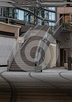View of an external modern staircase with stainless steel railing handle grip and glass