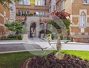 View on a facade of an old building from behind the stone flower vase