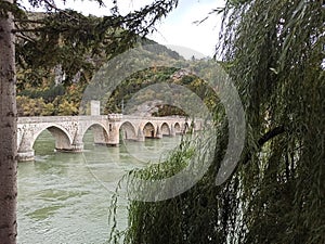 A view of famous bridge over Drina throug the trees, Visegrad, Bosna and Herzegovina