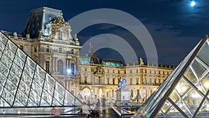 View of famous Louvre Museum with Louvre Pyramid at night timelapse hyperlapse. Paris, France