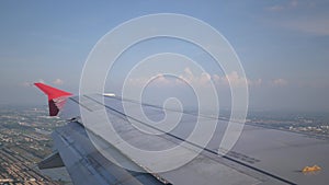 view of farm field while flying over fluffy cloud sky scape in daytime from airplane window with wing view ,Aerial view above the