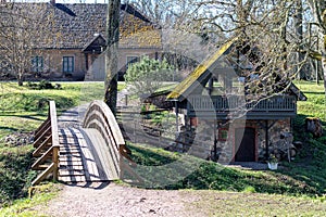 view of a farm with a house and a wooden bridge over the river