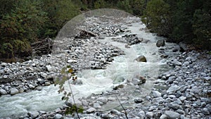 View of a fast flowing mountain river. The camera monitors the movement of water.