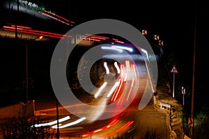 View of fast moving cars traffic, light trails along the dark road at night