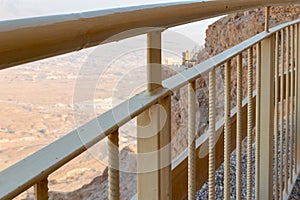 View  through the fence from the ruins of the fortress wall of the fortress of Masada to the ruins of the palace of King Herod and