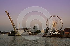 View of Ferris Wheel and lifted Footbridge over Motlawa during sunset, Gdansk