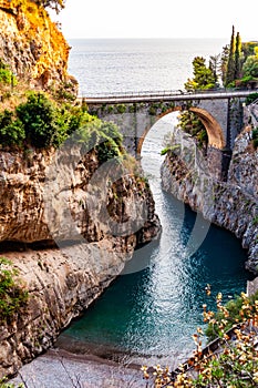 View on Fiordo di Furore arc bridge built between high rocky cliffs above the Tyrrhenian sea bay in Campania region. Unique cove