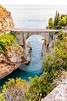 View on Fiordo di Furore arc bridge built between high rocky cliffs above the Tyrrhenian sea bay in Campania region. Unique cove