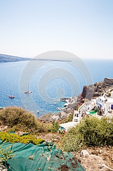 View of Fira town - Santorini island,Crete,Greece. White concrete staircases leading down to beautiful bay with clear blue sky