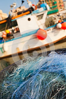 A view of a fishing net in front of the boat on the beach. Beautiful calm sea and water during an hot summer day