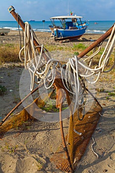 A view of a fishing net in front of the boat on the beach. Beautiful calm sea and water during an hot summer day