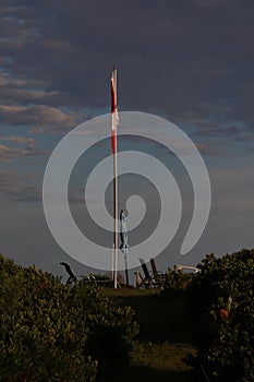 A view of a flagpole and umbrella on a clam day