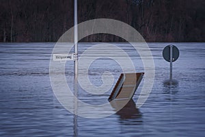 View of flooding on the Rhine river near Bonn, Benches, and signs near the river bank submerge