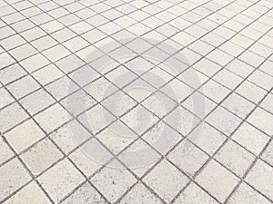 View of floor in square blocks of cement on the diagonal.