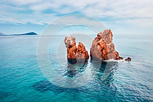 View from flying drone. Calm spring view of Red Rocks Gli Scogli Rossi - Faraglioni on the di Cea beach. Aerial morning scene of S photo