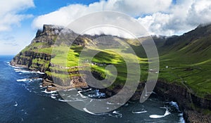 View from flying drone. Majestic morning scene of Mulafossur Waterfall. Stunning summer view of Vagar island, Faroe Islands,