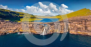 View from flying drone. Panoramic morning view of Bosdalafossur waterfall, that falls directly into the ocean. Exciting summer sce