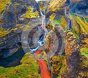 View from flying drone of waterfall in Fjadrargljufur canyon.