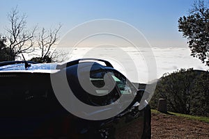 View of foggy and cloudy mountain valley landscape with car photo