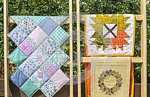 View of folded Quilts On Wooden Stand