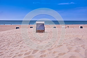 View of folding chairs on a sandy coast before the seascape under the blue sky