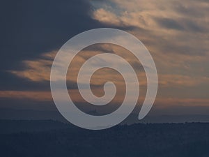 View of the foothills of Swabian Alb, Germany with the silhouettes of famous Hohenzollern Castle below brightening sky.